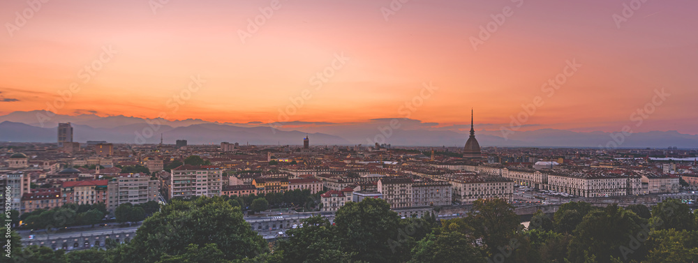 Turin, Italy. Panoramic view of the city in the evening after sunset. Skyline with the Mole in the evening. Banner Header Horizontal. July 1, 2022.