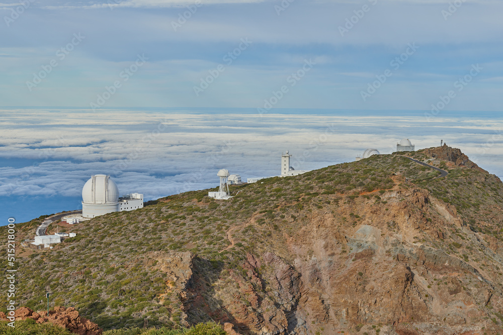 Roque de los Muchachos Observatory in La Palma. An astronomical observatory on a mountain top with blue sky copy space. Telescope surrounded by greenery and located on an island at the edge of cliff. Roque de los Muchachos Observatory in La Palma. An astronomical observatory on a mountain top with blue sky copy space. Telescope surrounded by greenery and located on an island at the edge of cliff.