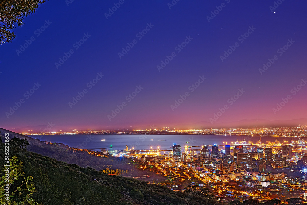 Signal Hill in Cape Town South Africa with copyspace against dark night sky background and the view of a coastal city. Scenic panoramic landscape of lights illuminating an urban skyline along the sea