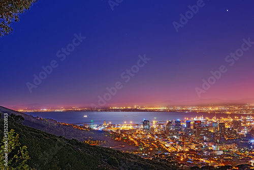 Signal Hill in Cape Town South Africa with copyspace against dark night sky background and the view of a coastal city. Scenic panoramic landscape of lights illuminating an urban skyline along the sea