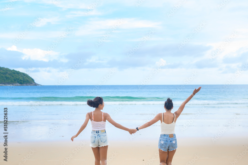Two attractive women friends enjoying and relaxing on the beach,  Summer, vacation, holidays, Lifestyles concept.