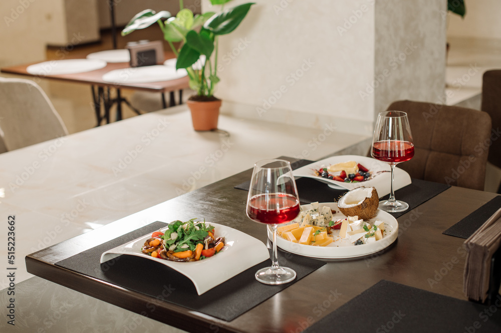 Served table with dishes and red wine in the restaurant