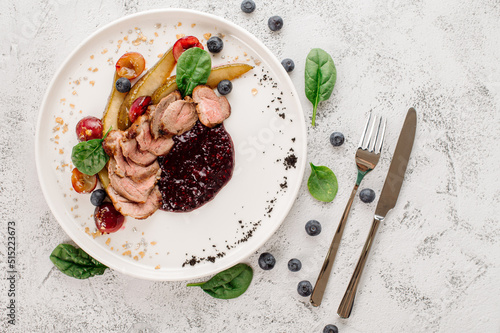 Dish of grilled duck medalions with cranberry sauce. Top view