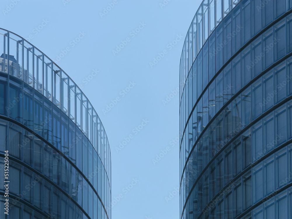 Close-up view of modern business towers with windows and a clear blue sky in the background