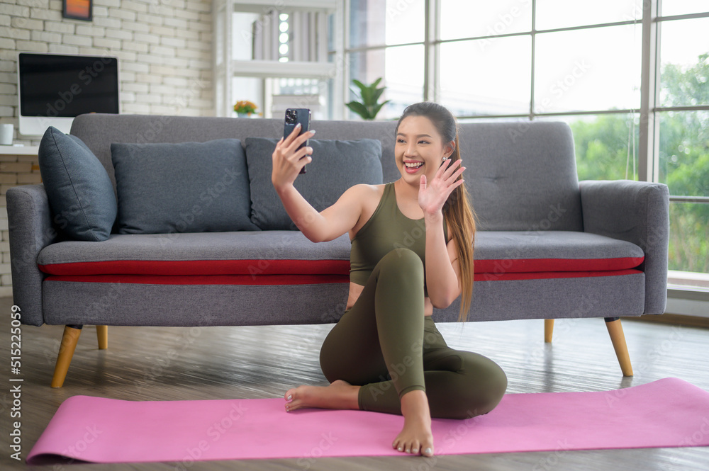 Obraz premium Young fitness woman in sportswear using smart phone while exercising at home, Healthy and Lifestyles.
