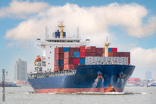 A large cargo ship, carrying a large number of containers floating in the middle of the sea, to transportion and import-export concept.