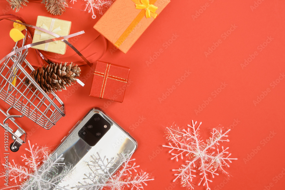 smartphone with three cameras and christmas decor on a red background smartphone with three cameras and christmas decor on a red background