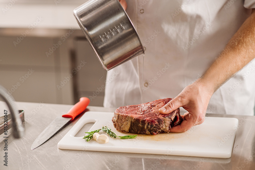 Chef is preparing a steak for friing on the restaurant kitchen