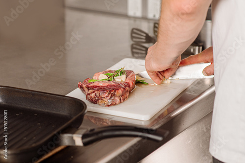 Chef is preparing a steak for friing on the restaurant kitchen