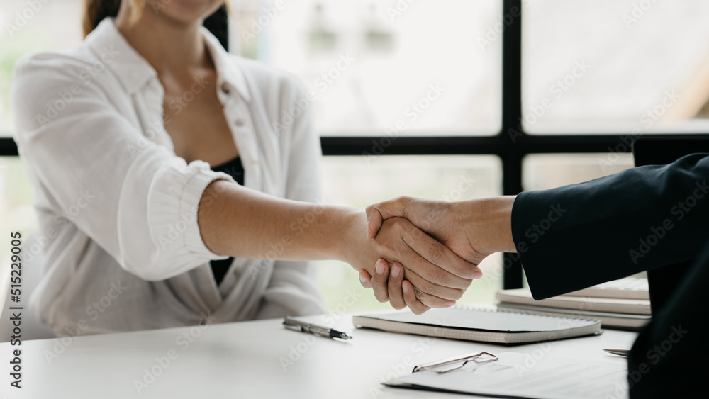 The job interviewer and the job applicant are holding hands after the job interview is finished. The concept of recruiting employees to work in the company, vacant positions. The job interviewer and the job applicant are holding hands after the job interview is finished. The concept of recruiting employees to work in the company, vacant positions.