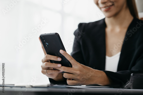 young businesswoman looking at financial information from a mobile phone, she is checking company financial documents, she is a female executive of a startup company. Concept of financial management.