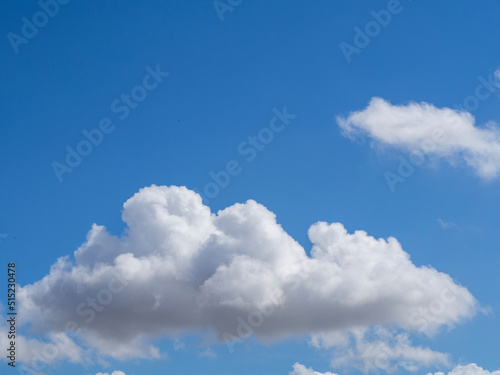 A soft fluffy white cloud in an azure-blue sky. Beautiful cloudy sky © Alekskan12