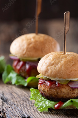 Close-up shot of fresh juicy burgers on wooden old table