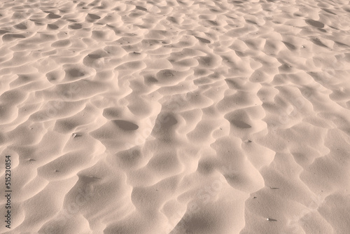 Sand beach texture background on summer season, dry sand on the seashore, desert. Beach sand - the art of nature. Sand dune desert. The uneven surface of a sea beach. Nature close-up abstract.