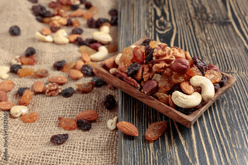 Mix of nuts and raisins on a wooden table.