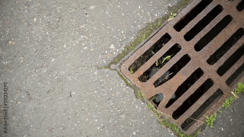 Old metal sewer grate on an asphalt street, free space
