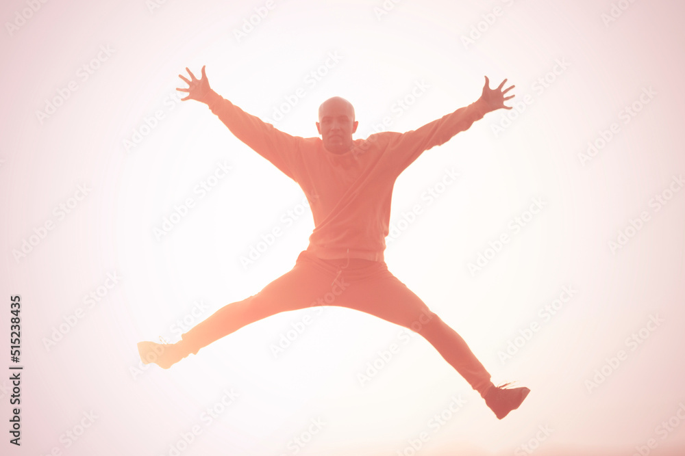 Young athletic man jumping high during sunset