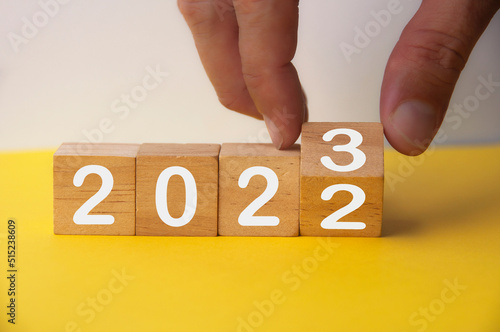 2023 happy new year symbol. Hand turning a cube from 2022 to 2023. Copy space. New year concept. #515238609