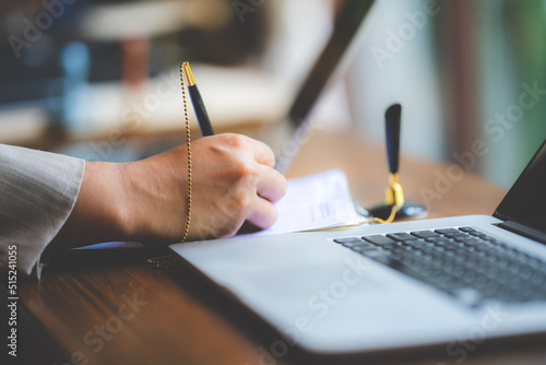 Hands of young man typing and working on digital tablet with financial and sales chart