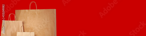 Three paper brown bags on a banner with a red background. Space for text or logo.