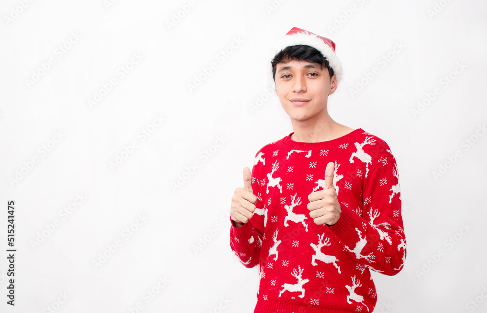 Fototapeta premium Joven Hombre caucasico con los pulgares arriba vestido con ropa navideña en un fondo blanco aislado 