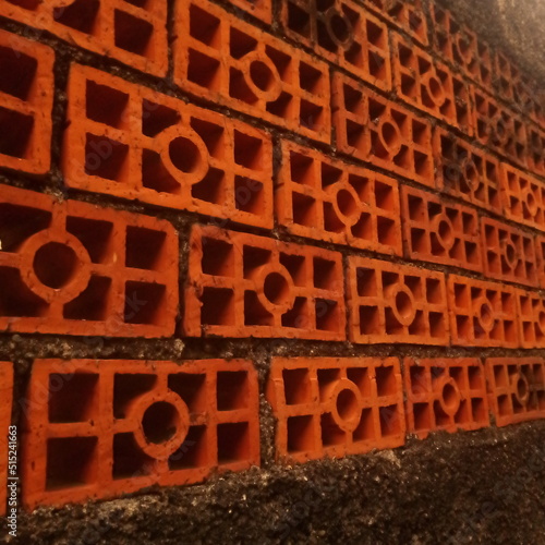 red brick ventilated wall divides a house with a small road next to it for pedestrian traffic in a village in Pamulang near Jakarta Indonesia photo