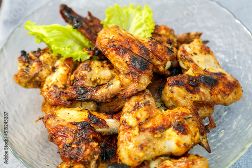 Chicken wings in a plate on a napkin on a wooden table. horizontal photo © finist_4