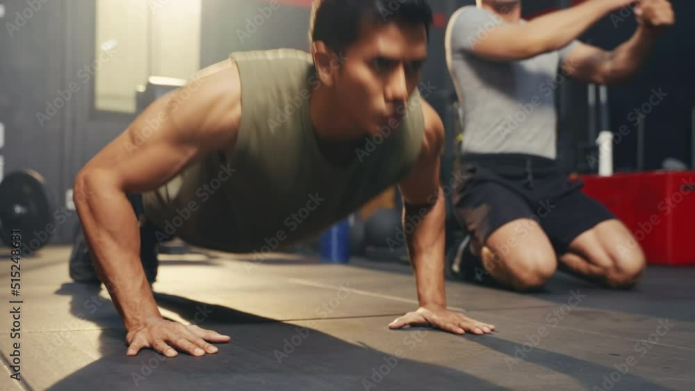 Asian strong athlete man doing push-up with friend in the gym. Asian strong athlete man doing push-up with friend in the gym.