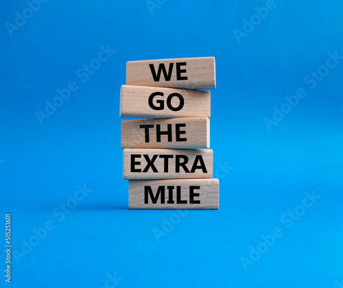 We go the extra mile symbol. Wooden blocks with words 'We go the extra mile'. Beautiful blue background. Business and 'We go the extra mile' concept. Copy space.