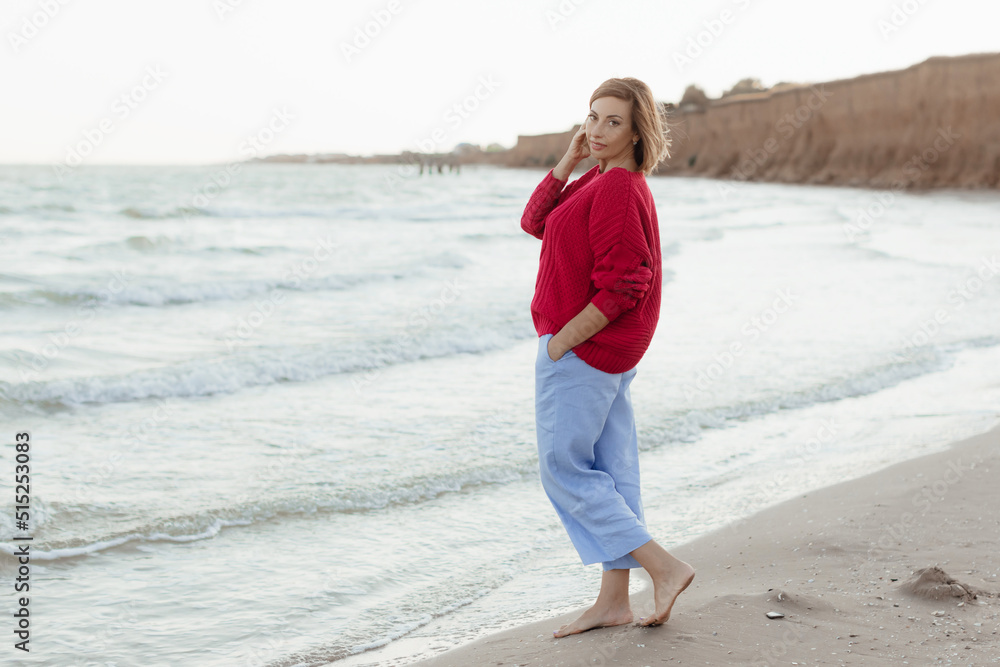 Happy mature woman feeling the breeze at beach. Beautiful middle aged woman on beach. Copy space. Happy mature woman feeling the breeze at beach. Beautiful middle aged woman on beach. Copy space.