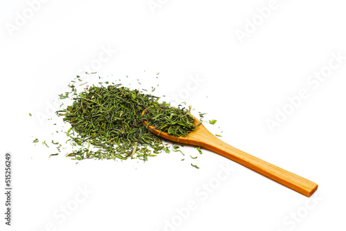 Sprinkled oregano seasoning from a wooden spoon on a white background. Close-up