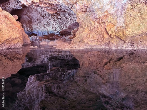 Cave grotto in the sea with a reflection of rocks in clear sea water.