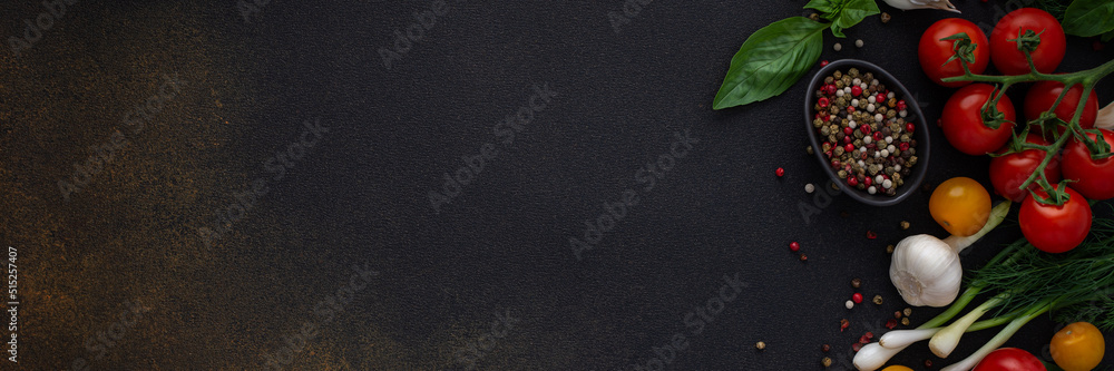 Food banner, fresh ripe red and yellow tomatoes, spices and basil leaves, garlic and green onions on a dark background, healthy food concept, copy space, top view Food banner, fresh ripe red and yellow tomatoes, spices and basil leaves, garlic and green onions on a dark background, healthy food concept, copy space, top view