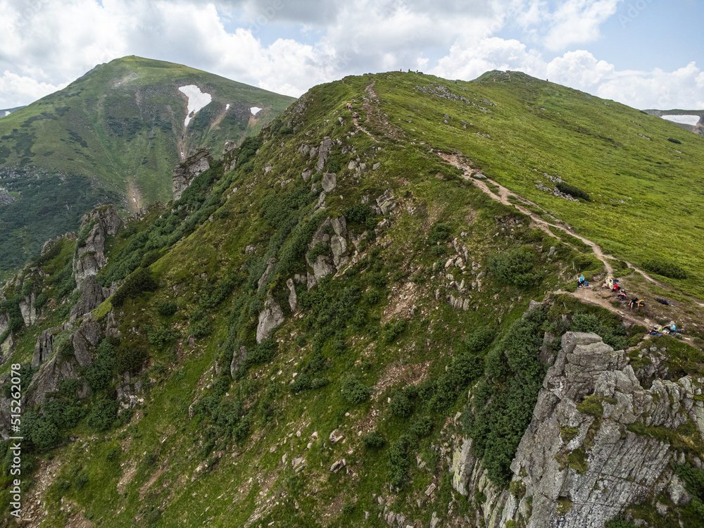 Fototapeta premium Panoramic aerial view of mountains in summer. Hiking destination. Alpine meadow
