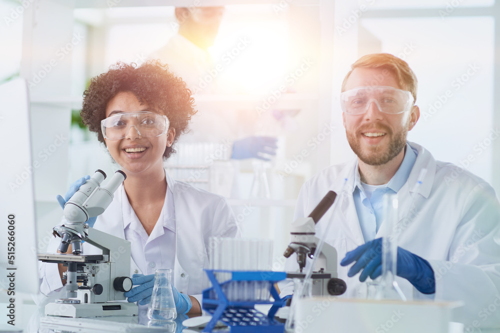 Smiling scientists looking at camera arms crossed in laboratory Smiling scientists looking at camera arms crossed in laboratory