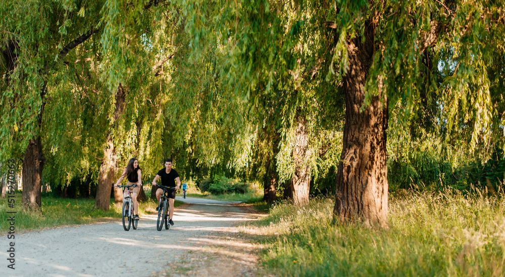 Fototapeta premium Young couple spend time riding bicycles together in the park