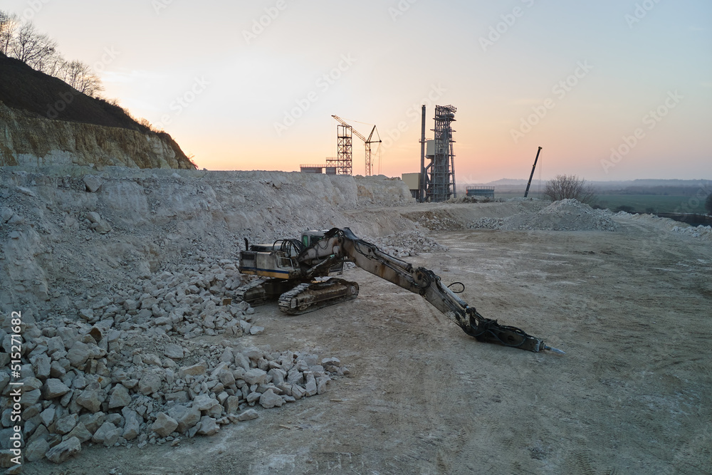Open pit mining site of construction sand stone materials with excavator equipment for digging of gravel resources at quarry