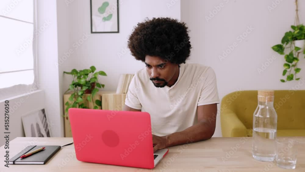 Young african american man working on laptop from home. Front view of afro hispanic guy using computer at workspace. High quality 4k footage Young african american man working on laptop from home. Front view of afro hispanic guy using computer at workspace. High quality 4k footage
