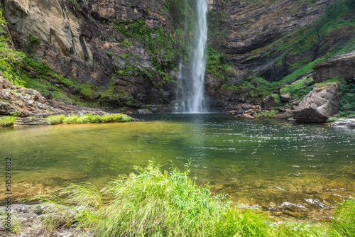 Beautiful view to big wild green waterfall and rocky wall