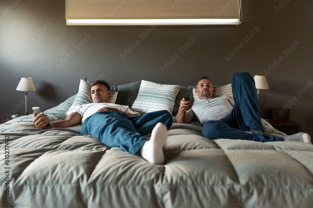 Gay male couple relaxing in bed. Gay male couple relaxing in bed.