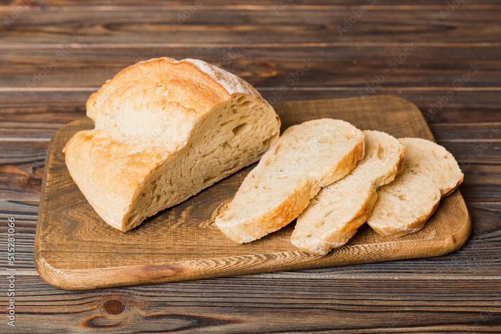 Assortment of freshly sliced baked bread with napkin on rustic table top view. Healthy unleavened bread. French bread slice