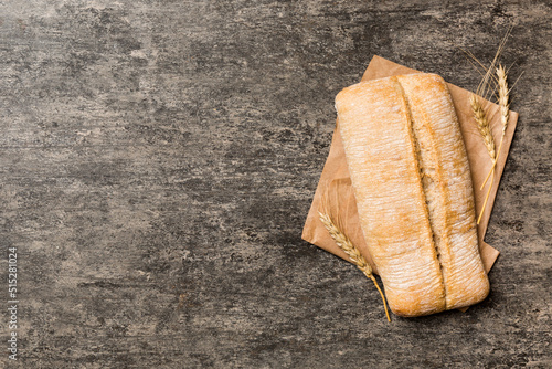 Fresh ciabatta bread on napkin on rustic background, Italian bread top view