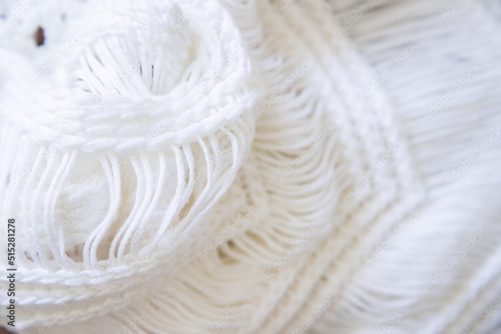Background made with white knitted fabric threads making a nice and cozy texture. Abstract white image resembling a fabric. Close-up image. Background made with white knitted fabric threads making a nice and cozy texture. Abstract white image resembling a fabric. Close-up image.