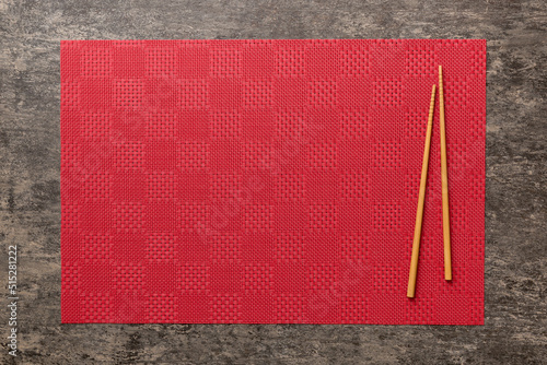 Wall Mural Two chopsticks and bamboo mat on cement background