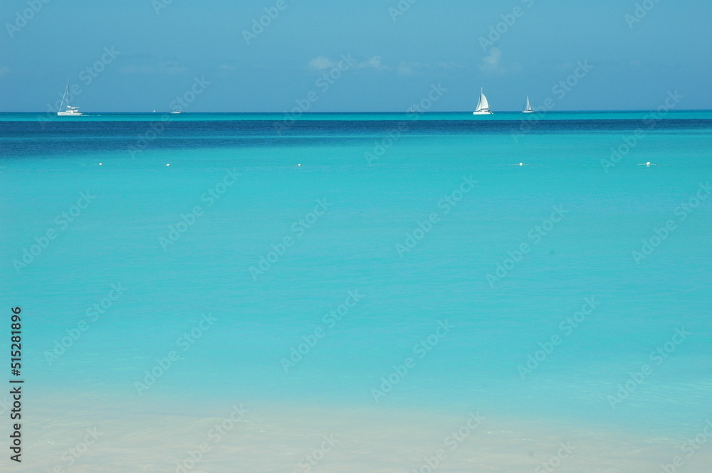 sailboats in the distance of an expanse of calm Caribbean ocean.