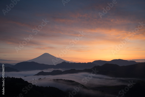 オレンジ色に染まる富士山と雲海