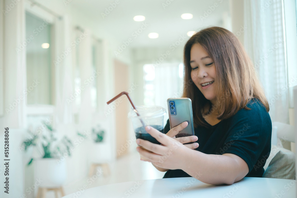 Asian female social media influencer taking photo of her black coffee before uploading to the internet. cheerful woman text messaging her friends in a modern and cute minimalist coffee cafe. Asian female social media influencer taking photo of her black coffee before uploading to the internet. cheerful woman text messaging her friends in a modern and cute minimalist coffee cafe.