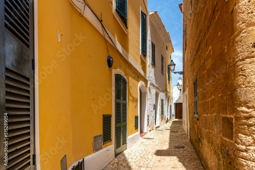 Fototapeta Naklejka Na Ścianę i Meble -  A long narrow alley street through the historic medieval center of Cuitadella de Menorca, Spain.