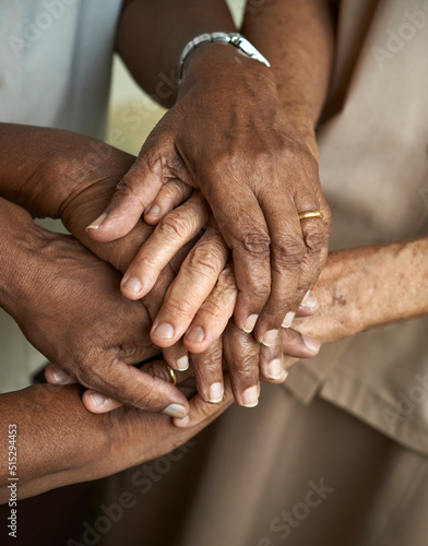 Close up of elderly people putting their hands together. Friends with stack of hands showing supporting each other