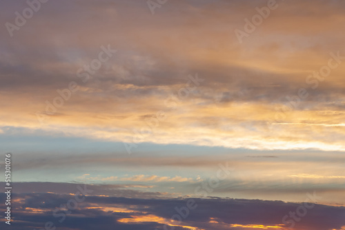 Beautiful evening sky with delicate clouds with orange and lilac, golden shades
